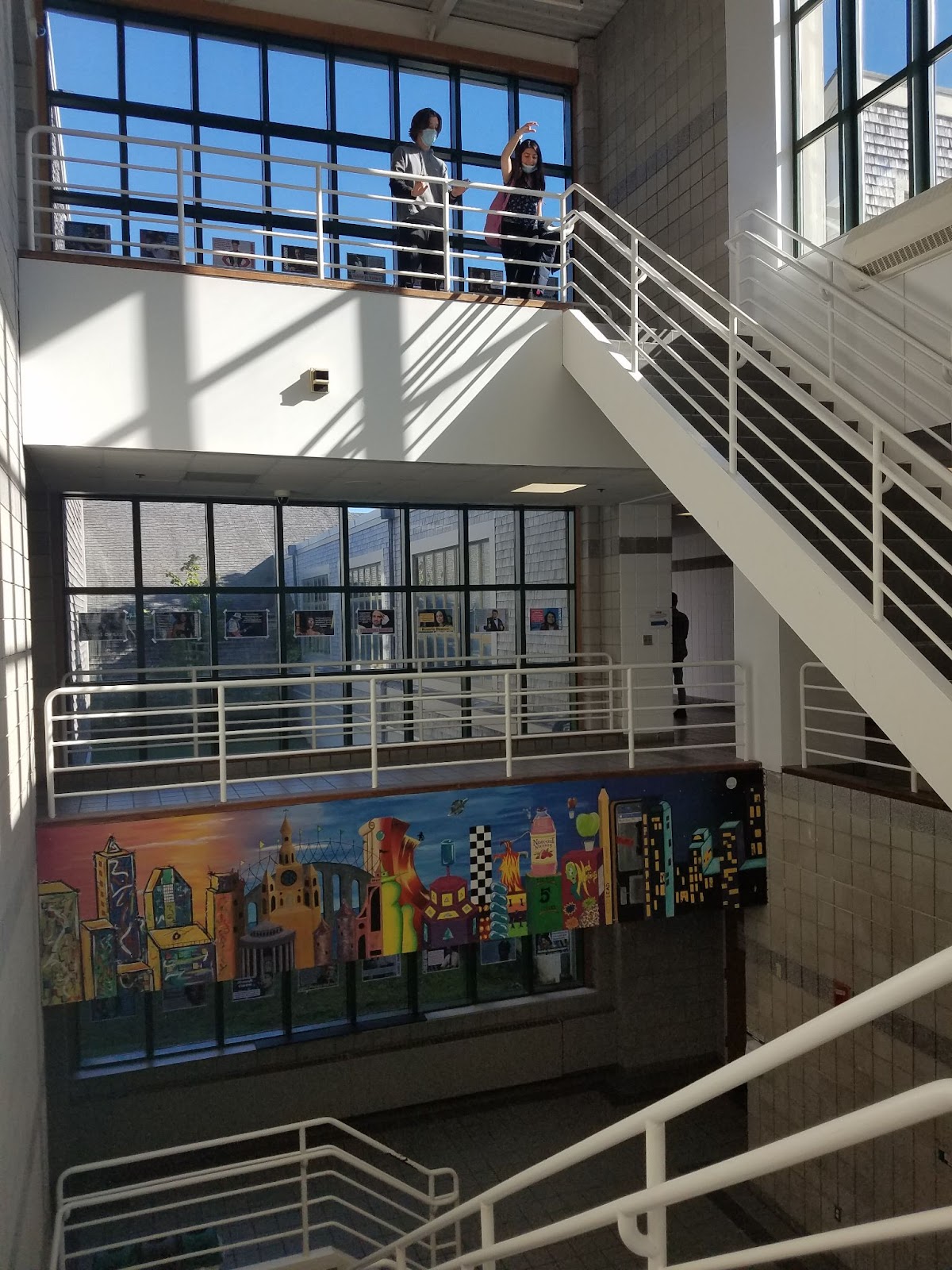 Two students dropping a bouncy ball down a three story stairwell.